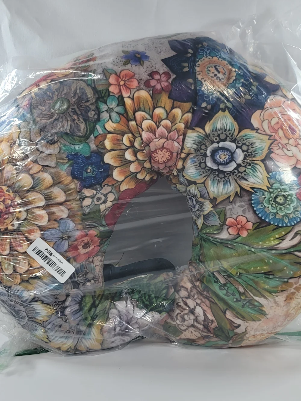 C-shaped nursing pillow featuring a vibrant, bohemian floral pattern